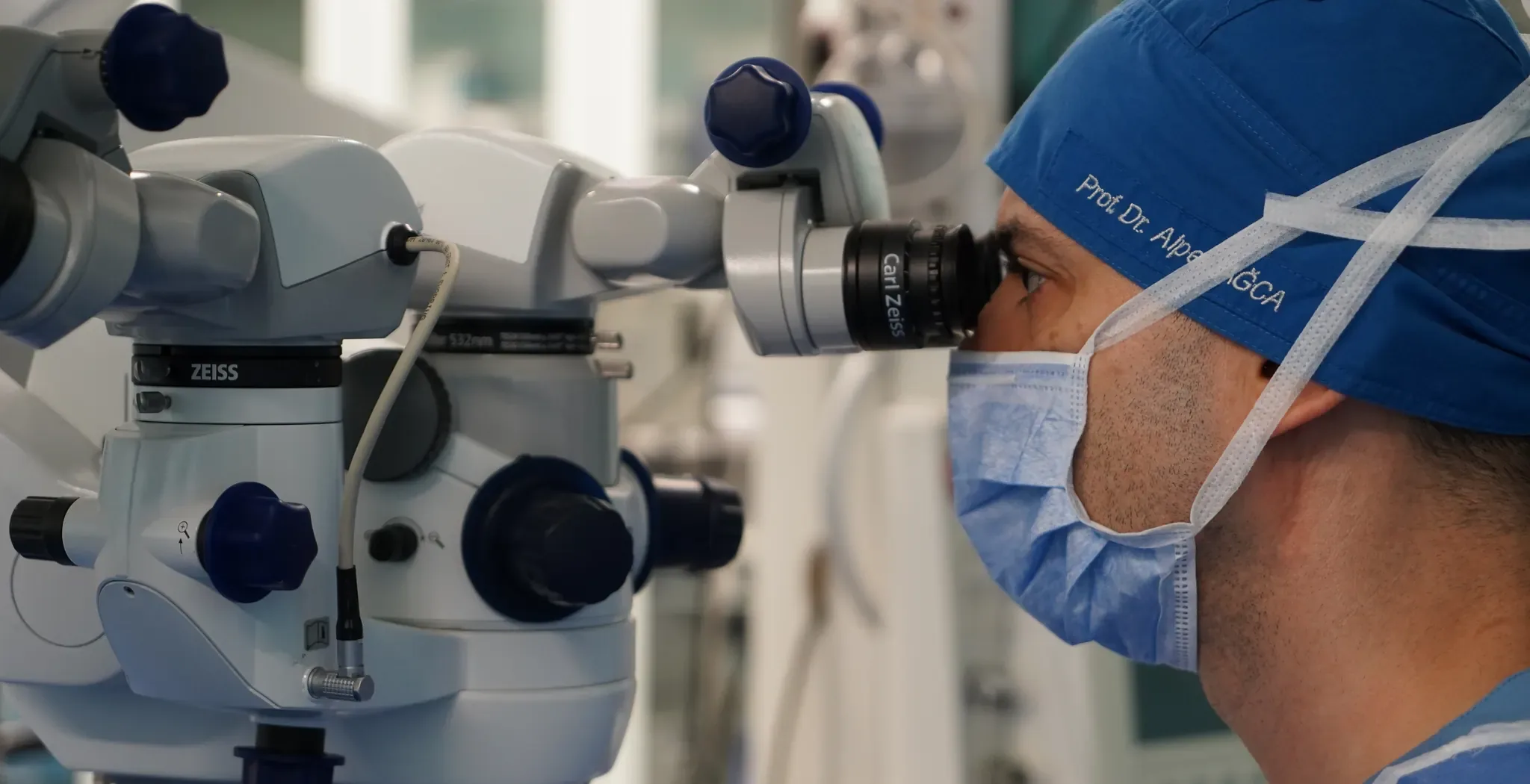 Prof. Dr. Alper Ağca ameliyathanede Carl Zeiss cerrahi mikroskobunun okülerinden bakarken